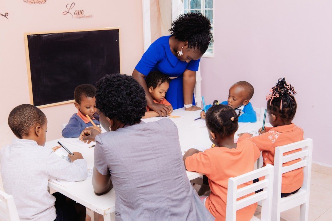 teacher-guiding-children-drawing-at-a-table-kpkrpy6piig